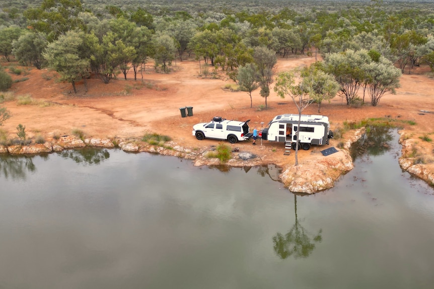 A caravan beside a rock pool in outback Queensland.