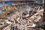 Firefighters and rescue workers search through piles of rubble at the site of a collapsed building in Mumbai.