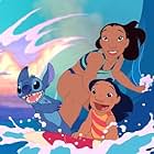 A young Hawaiian girl named Lilo (right), her sister Nani (middle), and their "dog" Stitch escape their troubles by catching a wave.