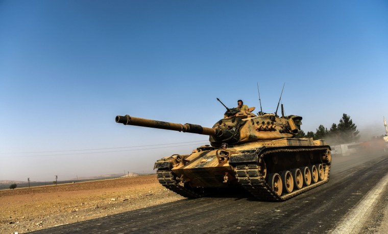 Image: A Turkish army tank drives towards Syria in the Turkish border city of Karkamis