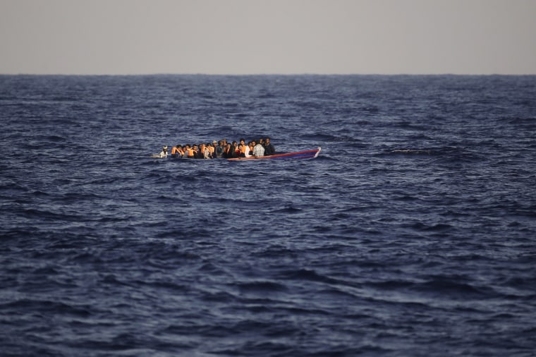 Image: Migrants and refugees flee Libya on board of a wooden boat.