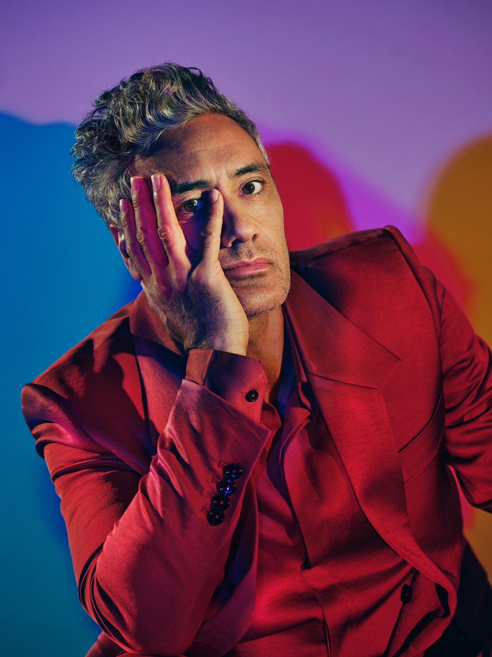 Photograph of Taika Waititi with his hand on his face