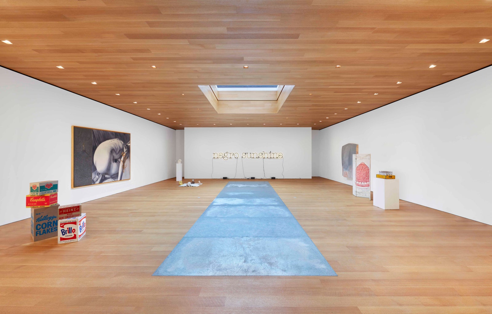 a large room with wood paneling and white walls and art