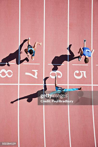 runner crossing finishing line on track - track event stock pictures, royalty-free photos & images
