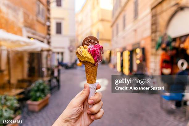 eating ice cream in the streets of rome, personal perspective view - gelato foto e immagini stock