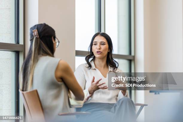 gesti e discorsi della giovane donna adulta durante l'intervista con la donna d'affari - parlare foto e immagini stock