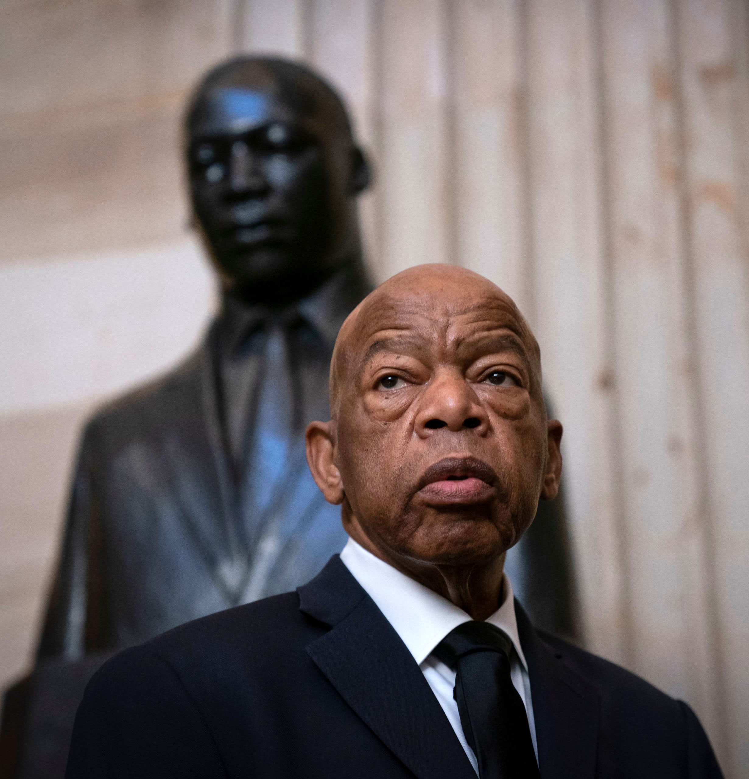 Rep. John Lewis standing in front of a bust of Rev. Martin Luther King Jr.