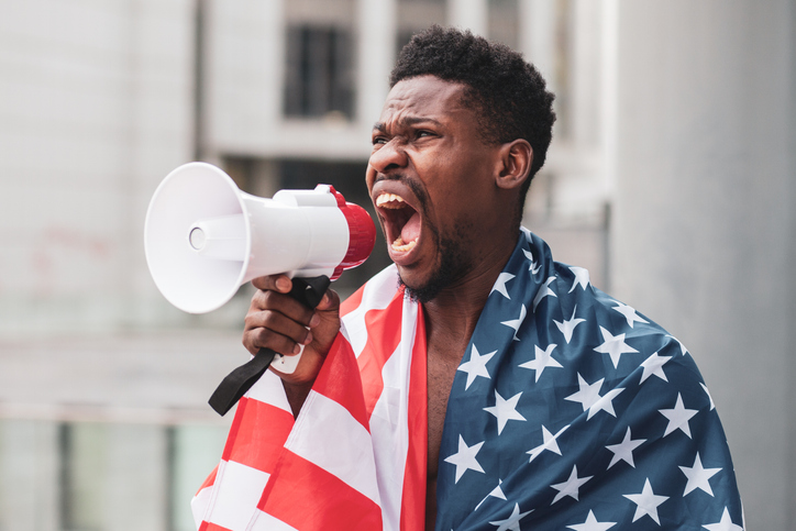 African american guy with usa flag protests and shouts