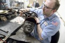 David Hobbs, an employee at Art Castings of Colorado, touches up a wax mold of Jackie Robinson's head in Loveland, Colo. on Wednesday, May 8, 2024. The original statue was cut off at the ankles and stolen from a park in Wichita, Kansas in January. The Colorado foundry cast that sculpture in 2019 and, luckily, still had the original plaster and rubber molds.