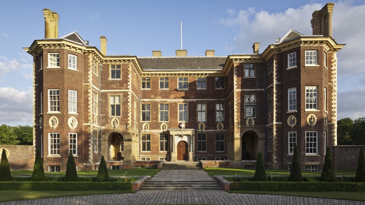 The north front of Ham House, London, constructed of brown-coloured brick, with a central block and wing on either side
