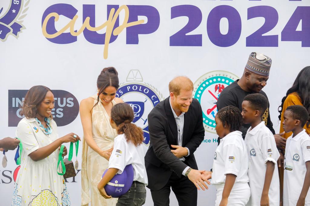 Prince Harry and Meghan Markle greet children in Nigeria.