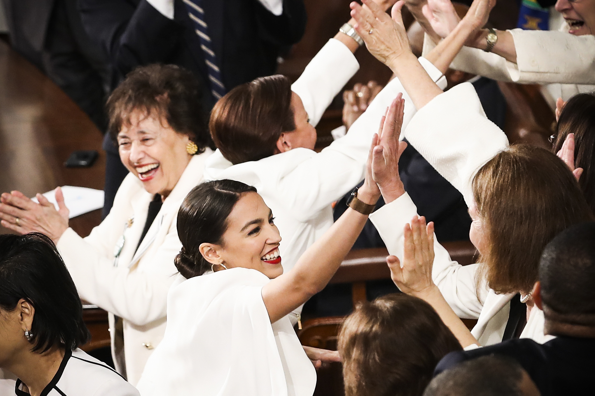 Rep. Alexandria Ocasio-Cortez (D-NY) and other female lawmakers cheer during President Trump’s State of the Union address.