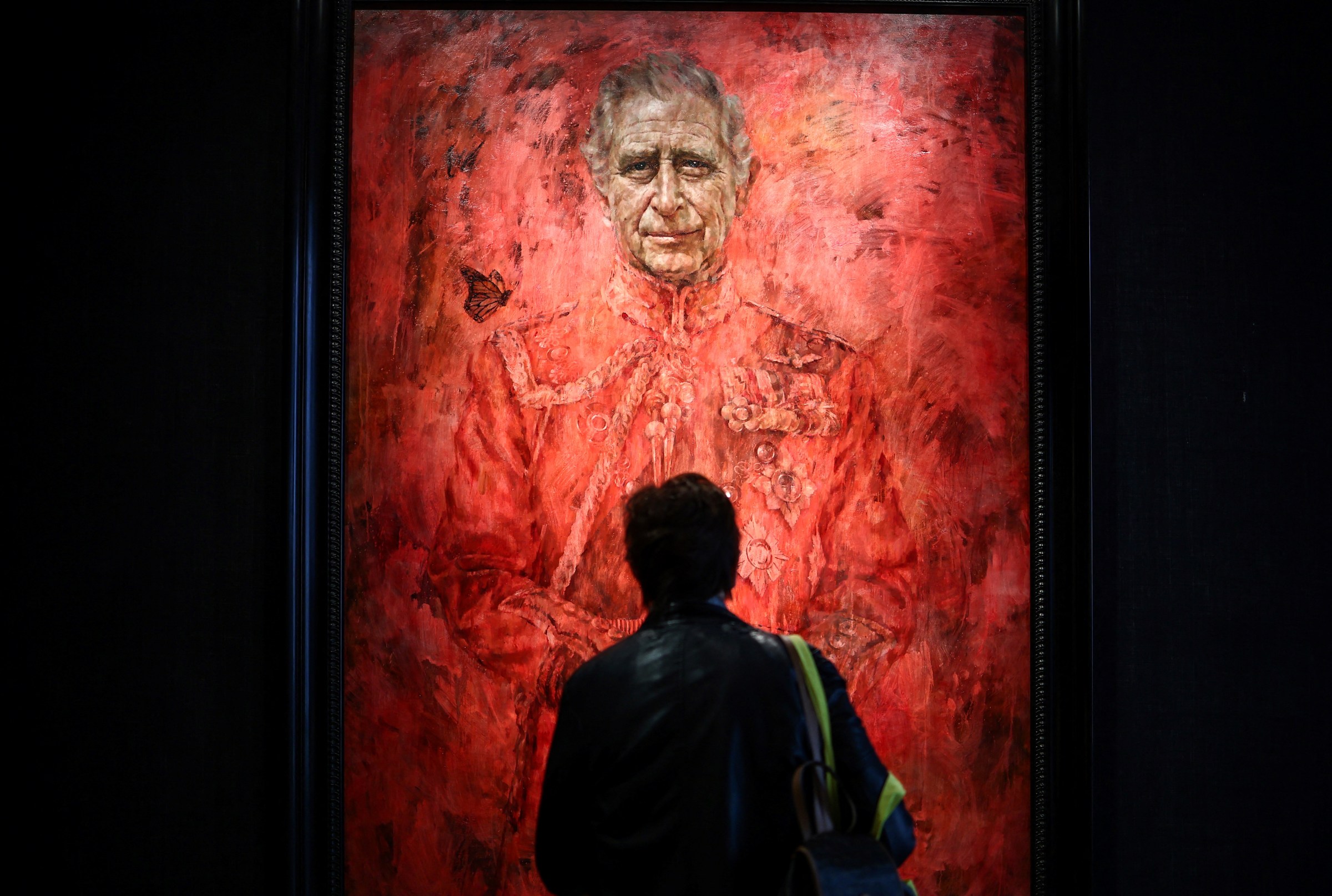 A visitor looks at the new official portrait of King Charles III, painted by British artist Jonathan Yeo, displayed at the Philip Mould gallery, on Pall Mall, central London, on May 16, 2024