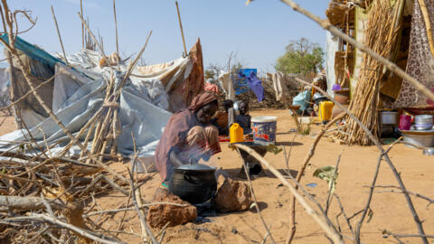 A young Sudanese refugee prepares a meal next to her shelter in the Farchana refugee camp, on April 7, 2024.