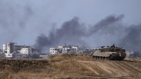 Backdropped by smoke rising to the sky after an explosion in the Gaza Strip, an Israeli tank stands near the Israel-Gaza border as seen from southern Israel, Monday, May 13, 2024.