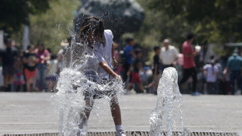 A girl cools herself down in a water fountain during a heat wave hitting the country in Guadalajara, Jalisco state, Mexico, on May 23, 2024.