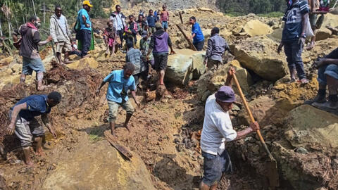 Villagers search through a landslide in Yambali, in Papua New Guinea, May 26, 2024.