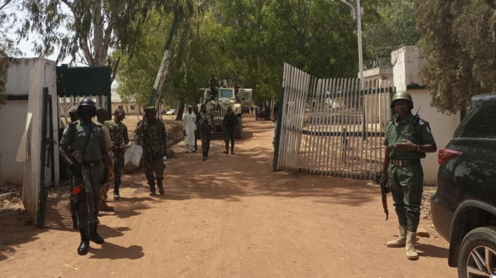Nigerian soldiers and police officers stand at the entrance of a school in Mando, Kaduna state, on March 12, 2021, after a kidnapping.