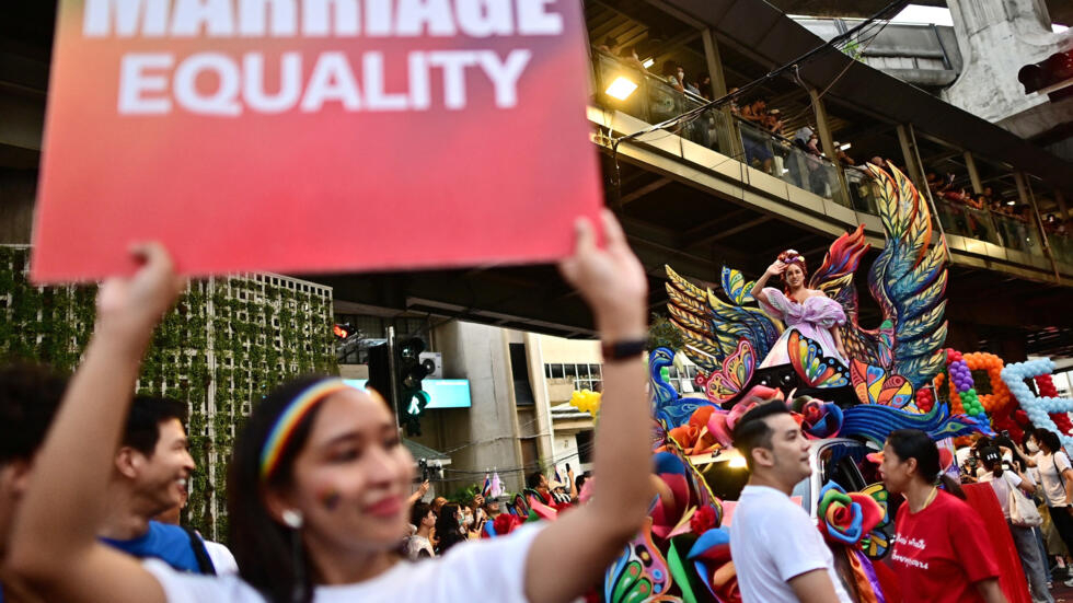 A member of the LGBTQIA+ community holds a placard calling for marriage equality during a pride march in Bangkok on June 4, 2023.