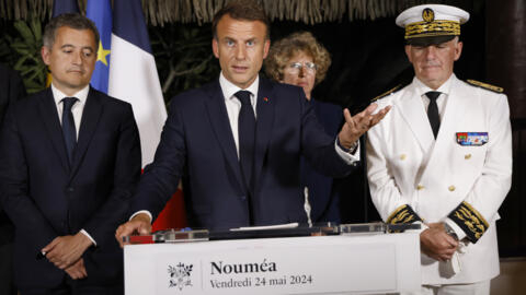 France's President Emmanuel Macron (C) delivers a speech next to France's Minister for Interior and Overseas Gerald Darmanin (L) and New Caledonia's High commissioner Louis Le Franc (R).