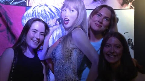 In this image taken from video, fans pose with a life-size image of Taylor Swift at a club that plays only Swift's music in Gothenburg, Sweden on April 30th, 2024.