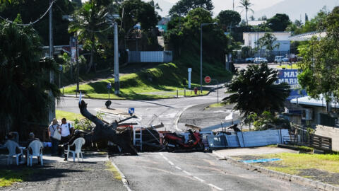 A temporary barricade, set up by residents with the aim of keeping watch over their neighbourhood in a peaceful manner, is seen along a road in Noumea on May 16, 2024.