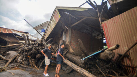 People look at damaged houses affected by heavy rain brought flash floods and landslides in Agam, West Sumatra province, Indonesia, Indonesia, May 12, 2024.
