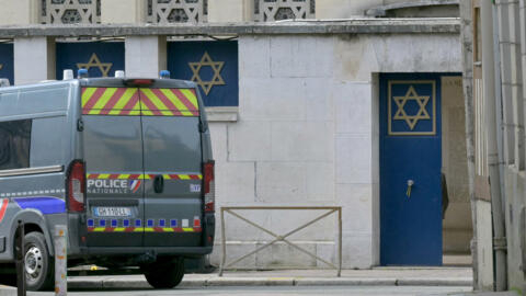 A police vehicle is parked by an entrance of a synagogue in Rouen, Normandy, where French police earlier killed an armed man who was trying to set fire to the building on May 17, 2024.