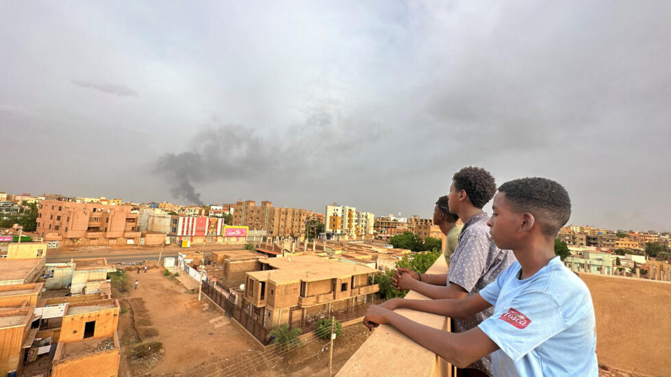 People watch as smoke rises during clashes between the army and the paramilitary Rapid Support Forces (RSF), in Omdurman, Sudan, July 4, 2023.
