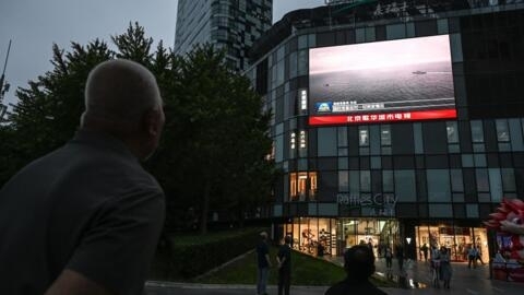 An outdoor screen shows a news coverage of China's military drills around Taiwan, in Beijing on May 23, 2024.