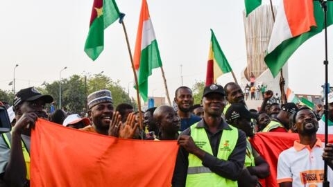 Supporters of the Alliance Of Sahel States (ASS) hold up flags as they celebrate Mali, Burkina Faso and Niger leaving the Economic Community of West African States (ECOWAS) in Niamey, Niger.