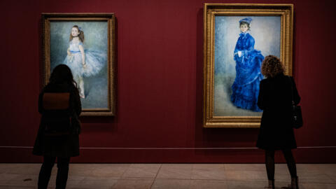 Visitors admire artworks by Impressionist painter Pierre-Auguste Renoir at the Musée d'Orsay in Paris, France. 