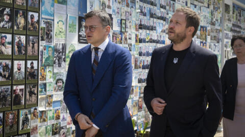 Ukraine's Foreign Minister Dmytro Kuleba, left, speaks to Estonia's Foreign Minister Margus Tsahkna after placing flowers at a memorial for fallen soldiers in Kyiv, Ukraine, Monday, June 3, 2024