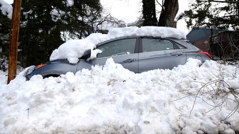 A car sits buried in snow from the blizzard on 9th Street in Boulder, Colo., on Thursday, March 24, 2016. (Jeremy Papasso/Daily Camera via AP)