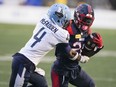 Montreal Alouettes running back Jeshrun Antwi (20) tries to rush past Toronto Argonauts defensive back Tarvarus McFadden (4) during first half pre-season CFL football action in Montreal, Saturday, May 25, 2024.
