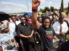 Malik Muhammad raises his fist during a demonstration calling for the firing and indictment of Texas State Trooper Brian Encinia, Sunday, July 26, 2015, in Katy, Texas. Sandra Bland was found dead in her cell on July 13 in the Waller County Jail, just days after being arrested by Encinia during a traffic stop. Authorities determined through an autopsy that Bland hanged herself with a plastic bag. (Brett Coomer/Houston Chronicle via AP)