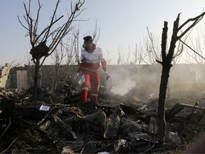 A rescue worker searches the scene where an Ukrainian plane crashed in Shahedshahr, southwest of the capital Tehran, Iran, Wednesday, Jan. 8, 2020.