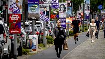 People walk past elections posters for the European elections in Frankfurt, 6 June 2024