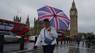 A woman walks outside the Houses of Parliament, in London.