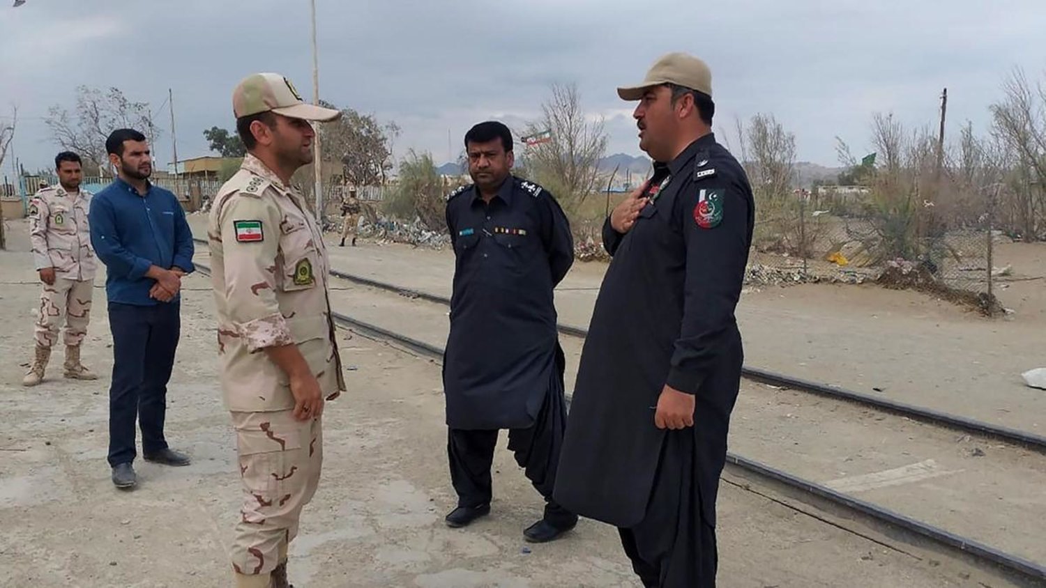 A Pakistani border security official (R) and an Iranian border official meet at Zero Point in the Pakistan-Iran border town of Taftan. (AFP)