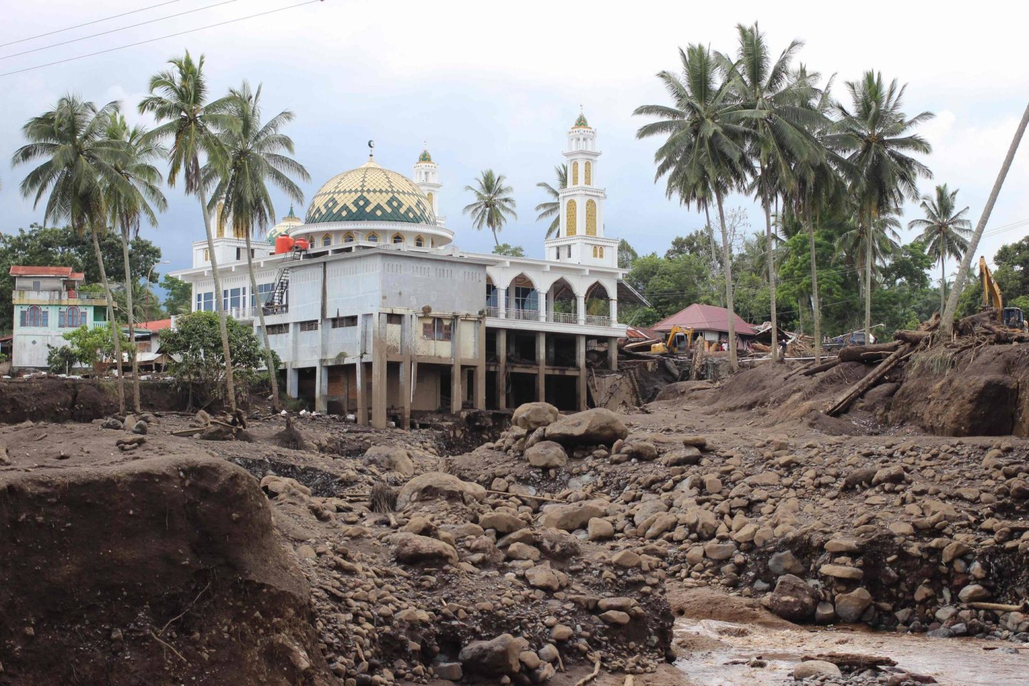 A mosque is seen past mud and debris following deadly flash floods and cold lava flow in Tanah Datar, West Sumatra, on May 13, 2024. (Photo by Ade Yuandha / AFP)