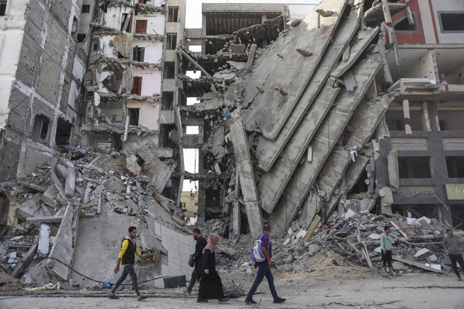 Palestinians walk through destruction in Gaza City on Friday, Nov. 24, 2023, as the temporary ceasefire between Israel and Hamas took effect. (AP)
