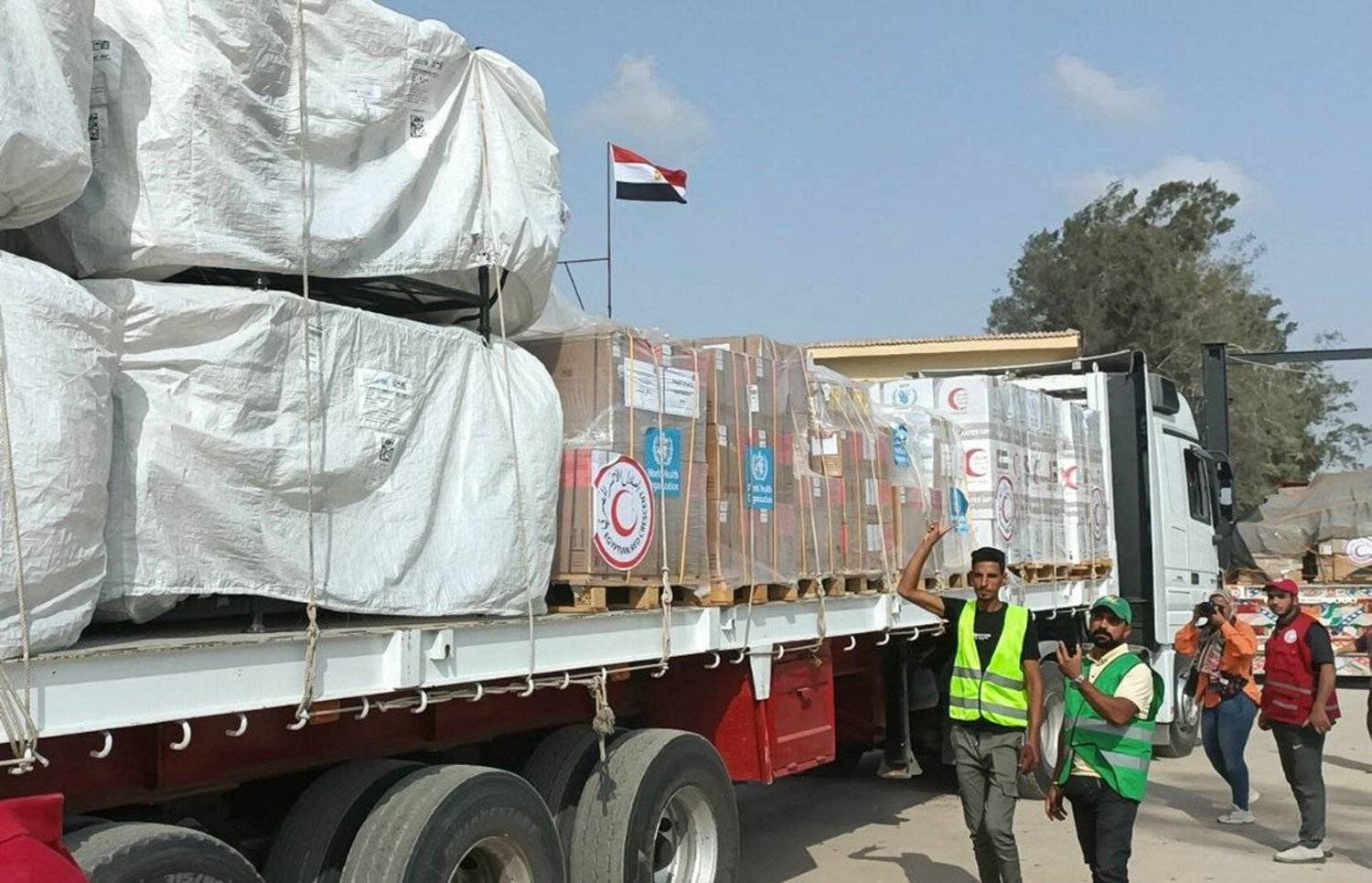 Egyptian Red Crescent members and volunteers gather next to a truck carrying humanitarian aid as it drives through the Rafah crossing from the Egyptian side, amid the ongoing conflict between Israel and Hamas, in Rafah, Egypt October 22, 2023. REUTERS/Stringer
