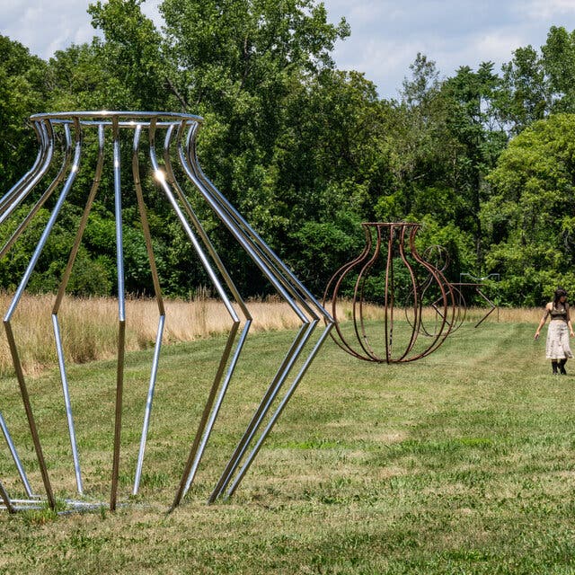 A line of hollow, oversize steel “vessels” by Maren Hassinger in a field near Hudson, N.Y. 